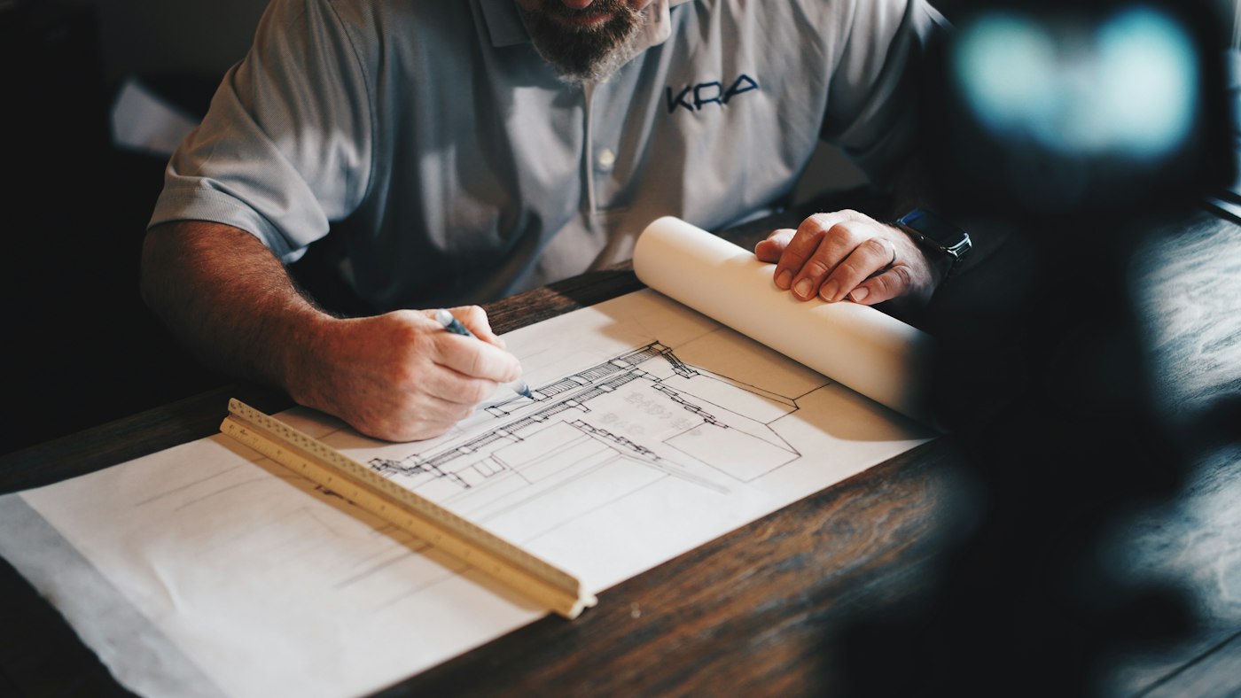 Plano arquitectónico trazado a mano sobre mesa de trabajo
